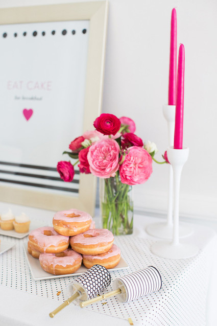Bright pink floral centerpiece with pink donuts