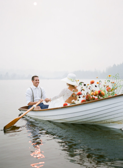End of summer retro engagement shoot in a rowboat full of flowers