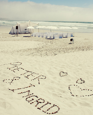 Couple's name etched on beach with rocks