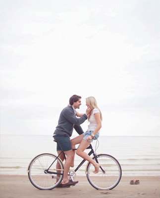Casual couple on a bike at the beach