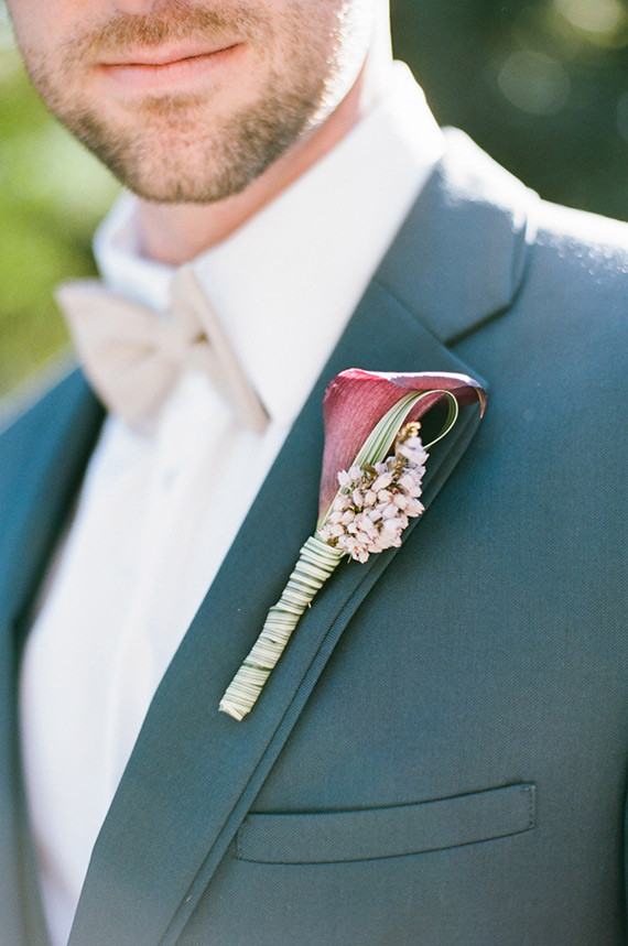 Plum boutonniere with dark blue suit
