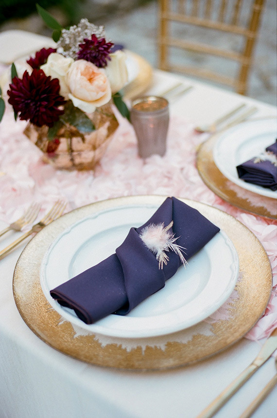 Gold plate with purple napkin and feather accent Inspiration
