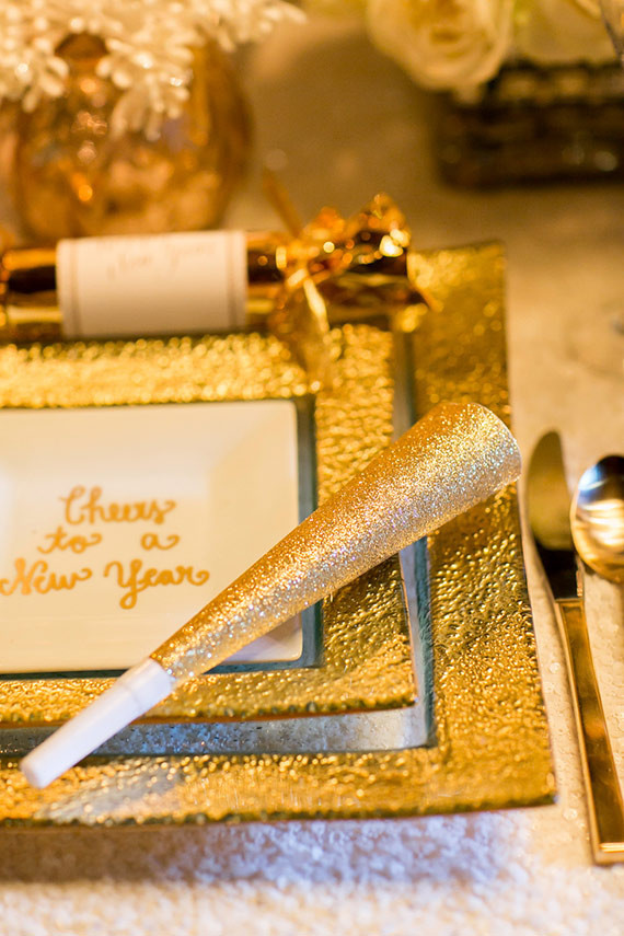 New Years gold place setting with blowhorn