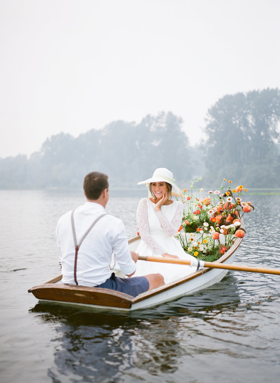 End of summer retro engagement shoot in a rowboat full of flowers