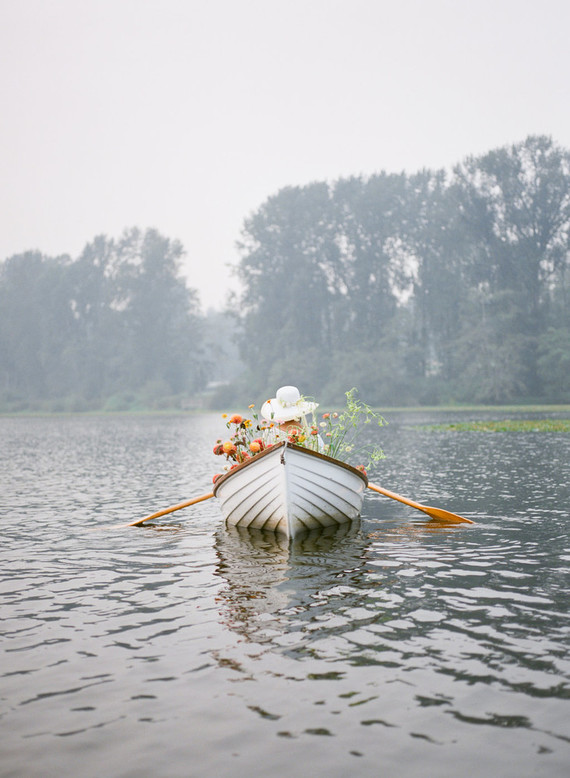 End of summer retro engagement shoot in a rowboat full of flowers