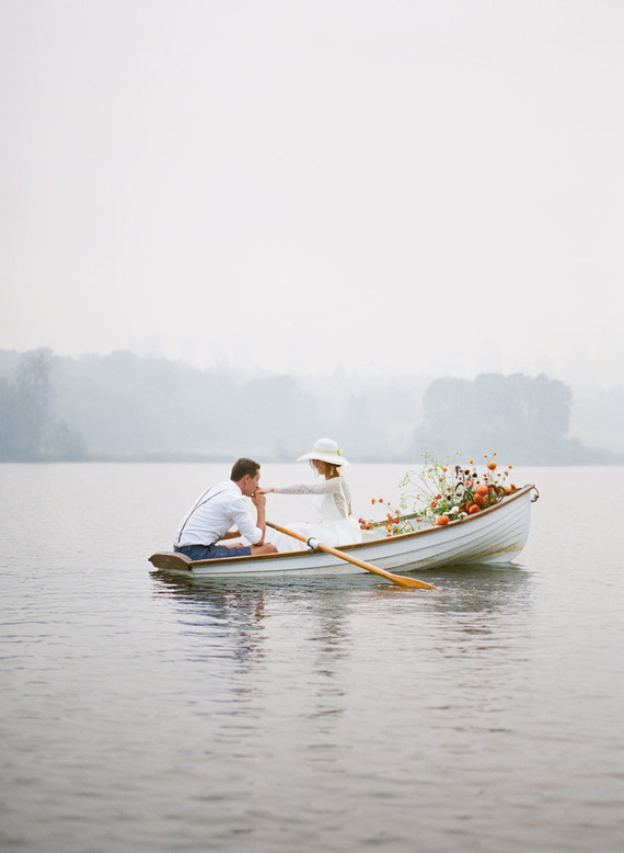 End of summer retro engagement shoot in a rowboat full of flowers