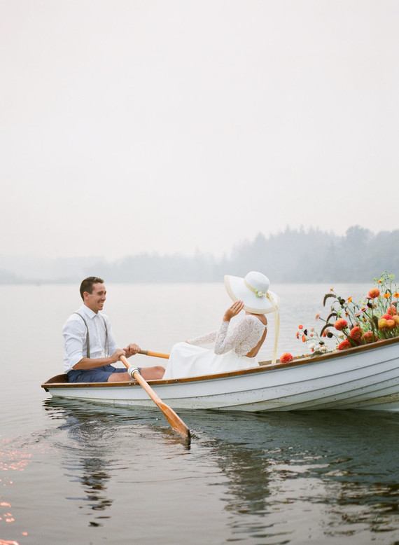 End of summer retro engagement shoot in a rowboat full of flowers