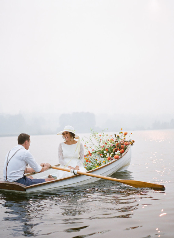 End of summer retro engagement shoot in a rowboat full of flowers