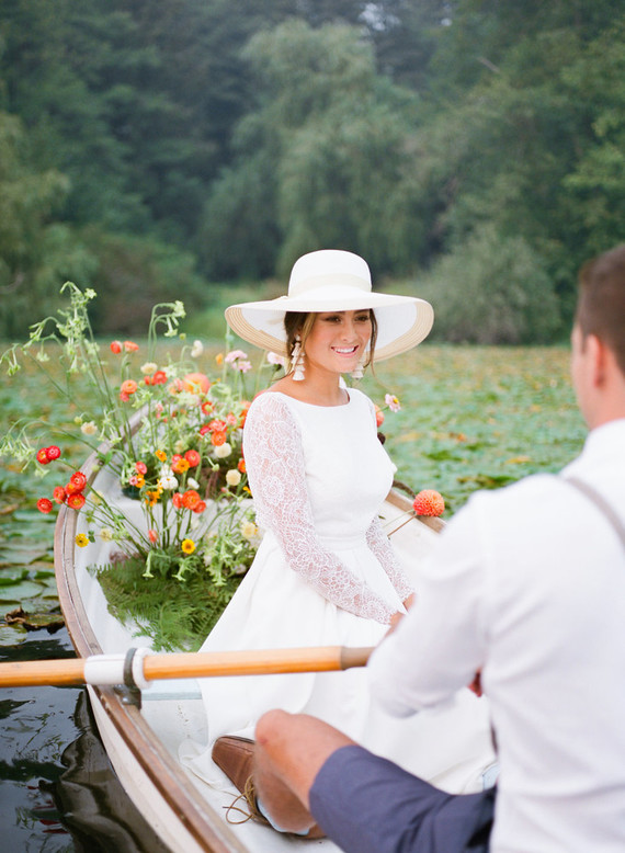 End of summer retro engagement shoot in a rowboat full of flowers