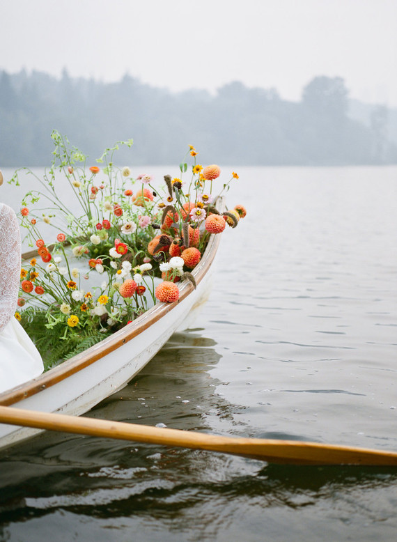 End of summer retro engagement shoot in a rowboat full of flowers