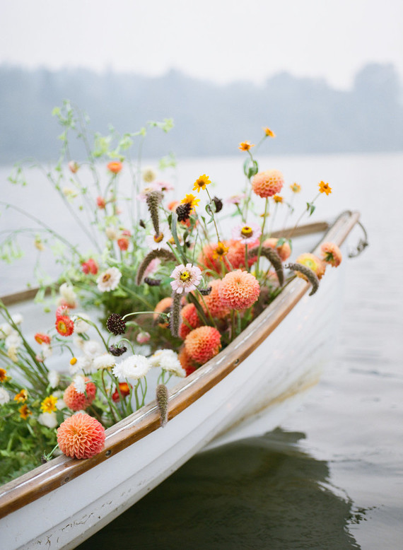 End of summer retro engagement shoot in a rowboat full of flowers