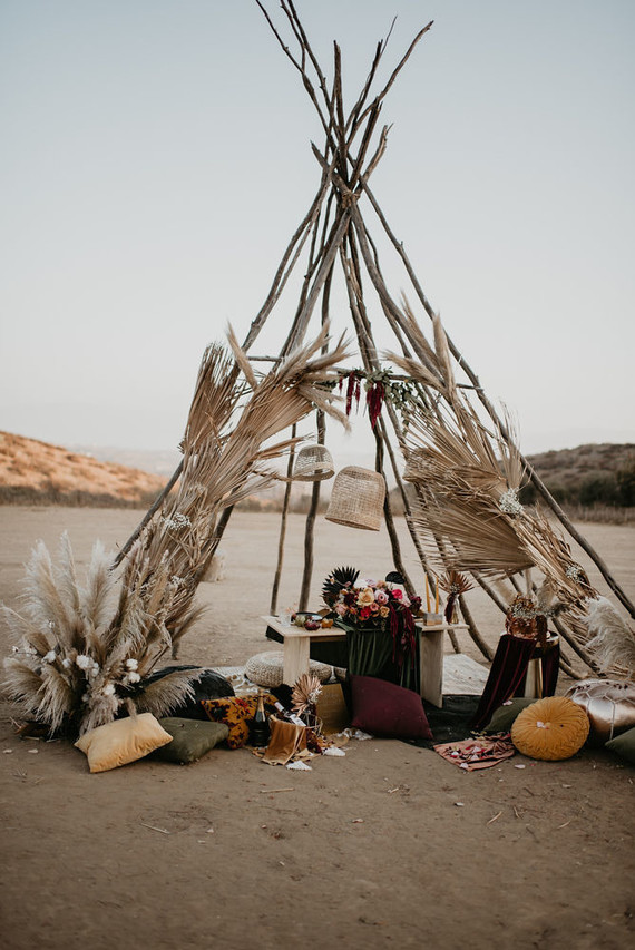 Boho vow renewal with a palm frond teepee at Wolf Feather Honey Farm