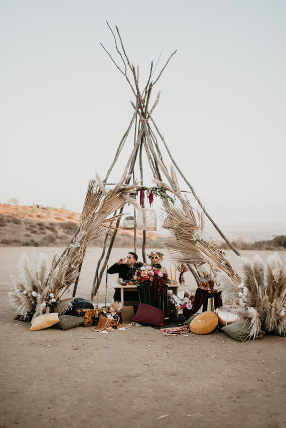Boho vow renewal with a palm frond teepee at Wolf Feather Honey Farm