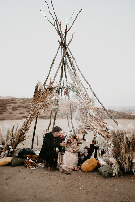 Boho vow renewal with a palm frond teepee at Wolf Feather Honey Farm
