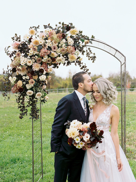 Amazing winter wedding fashion and bridal party style with a floral arch