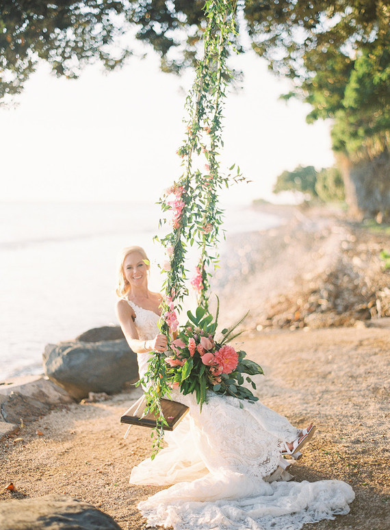 bride on a floral swing at her wedding in Maui
