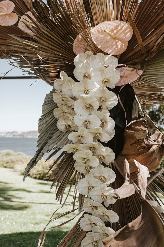 Palm leaf and orchid ceremony arch