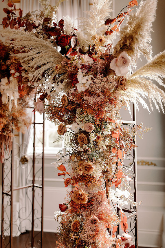Lush fall floral ceremony arch with pampas