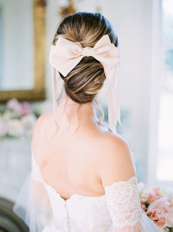 romantic bridal updo with pink bow