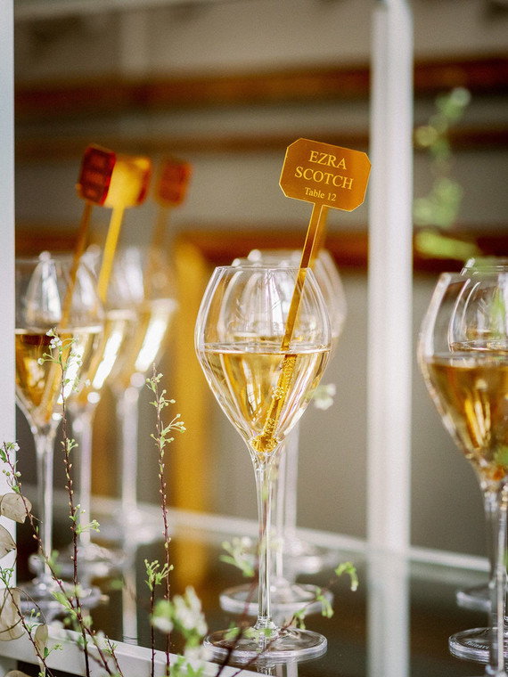 Champagne escort card display with gold drink stirs