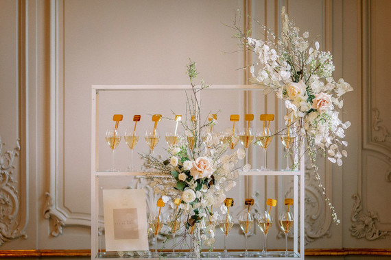 Champagne escort card display with gold drink stirs Inspiration