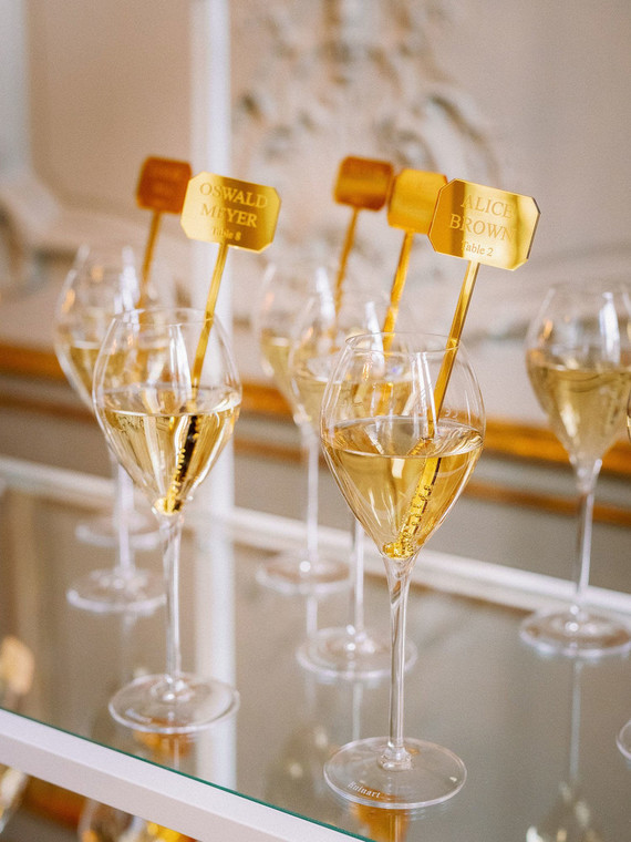 Champagne escort card display with gold drink stirs