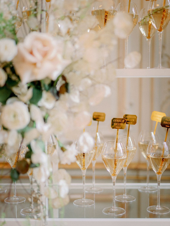 Champagne escort card display with gold drink stirs