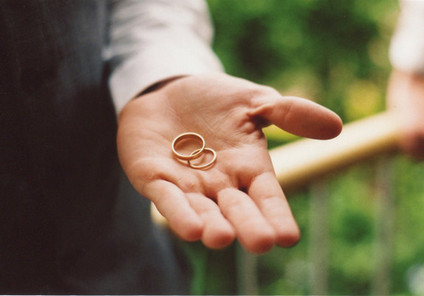 Groom holding couples' wedding bands