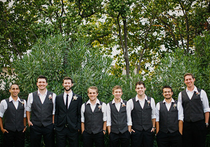 black vest and rolled up sleeves groomsmen