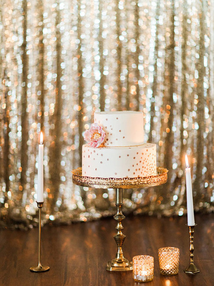 Gold stand with white cake and candles