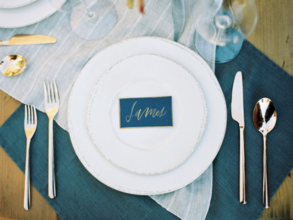 Blue white and gold place setting with escort card