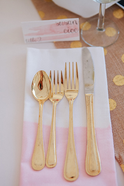 Gold flatware with pink and white napkin