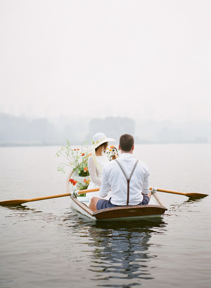 End of summer retro engagement shoot in a rowboat full of flowers