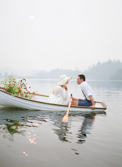End of summer retro engagement shoot in a rowboat full of flowers