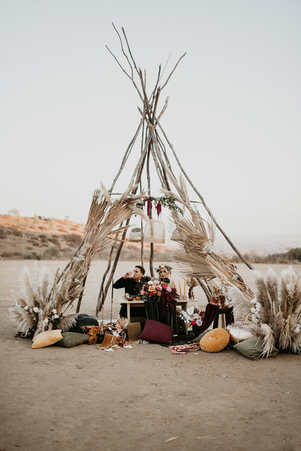 Boho vow renewal with a palm frond teepee at Wolf Feather Honey Farm