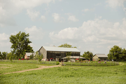 Farm to table summer barn wedding with pops of red and a PARADE