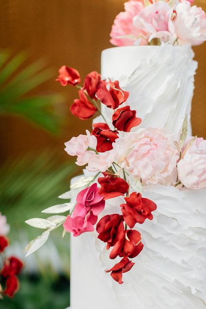 Ruffled floral wedding cake with pink details