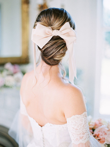 romantic bridal updo with pink bow