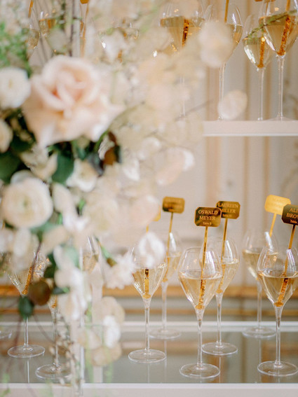 Champagne escort card display with gold drink stirs