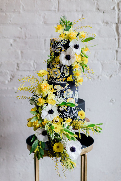 black wedding cake with anenomes and yellow flowers