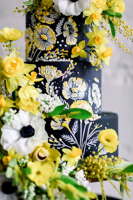 black wedding cake with anenomes and yellow flowers